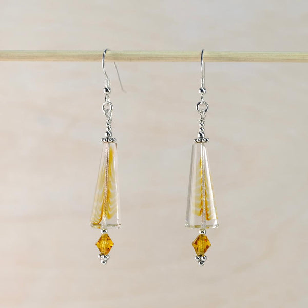 Pair of earrings with clear teardrop-shaped beads and yellow accents on a light background