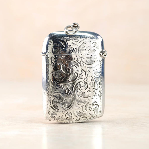 Silver vesta case with intricate engravings  with a hinged lid and a bale fixed centrally at the top