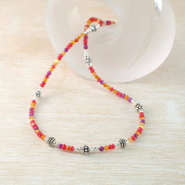 bead necklce with warm amber tones  and decorative silver beads.