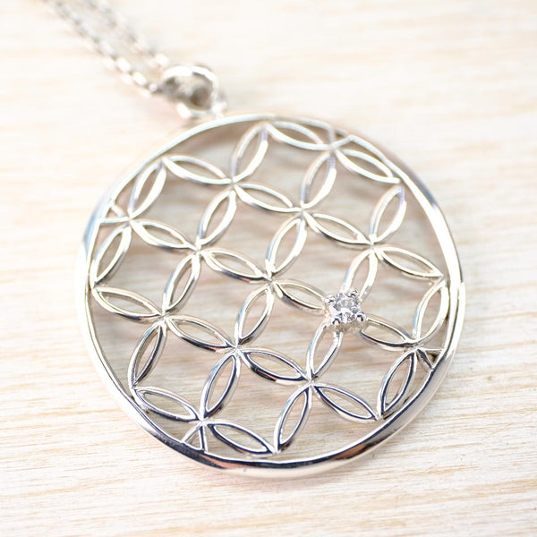 Silver necklace with a circular pendant and geometric filigree design.