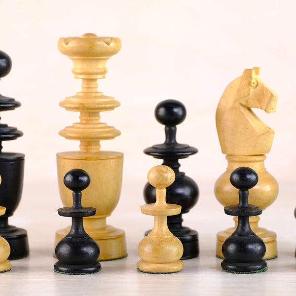 Set of black and beige chess pieces on a light background