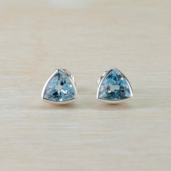 Bright blue cut stone, shaped in a rounded triangle shape surrounded in silver.