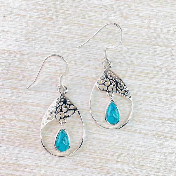 The overall shape is tear drop. In the top third of this is a filligree design with pretty cut outs and a wave shape edge. Hanging from this is a tear drop shape turquoise stone set in silver.