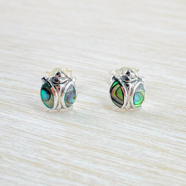 A pair of sterling silver stud earrings in the shape of ladybirds with abalone shell accents 