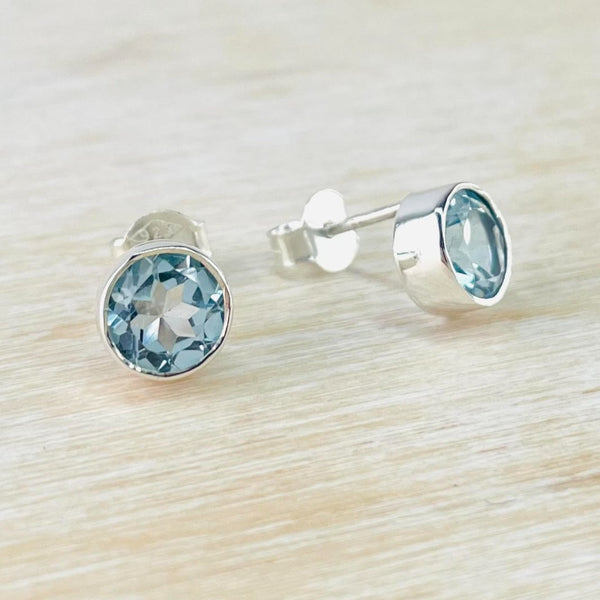 Round Sterling Silver and Faceted Blue Topaz Stud Earrings.