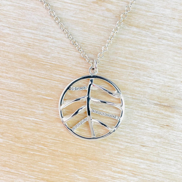 Round silver outline with twig like design inside  in 4 rows of two. Alternate twigs are set in sparkly little stones.