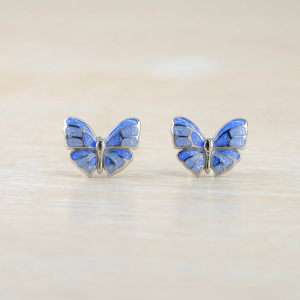 Butterfly design studs with a silver body and silver edges and veins within the wings. Blue and pale lilac enamel forms the wings.
