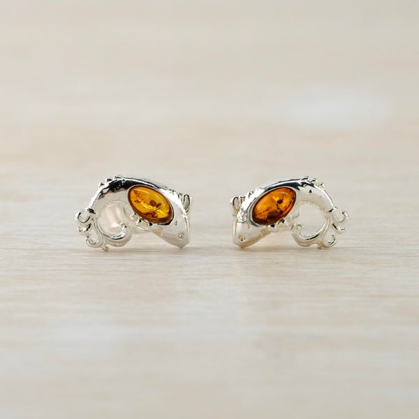 The earrings are shaped like a jumping fish with its tail and nose pointing down. There are small fins on the top, a little eye and a tummy made os clear amber.