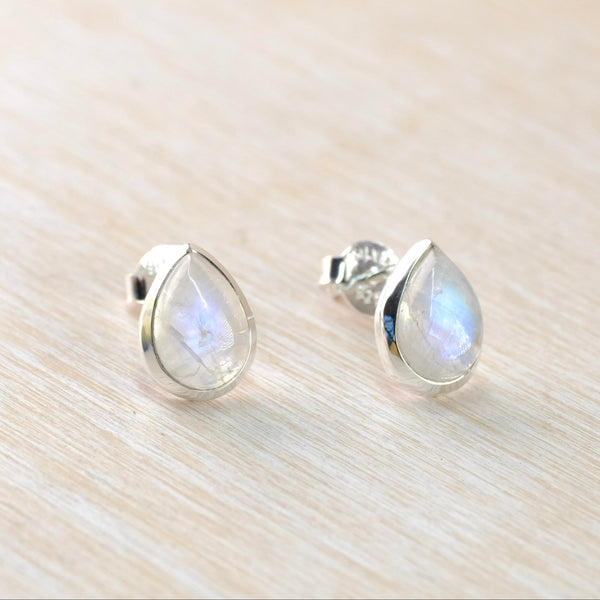 A pair of sterling silver stud earrings with rainbow moonstone teardrop cabochons.