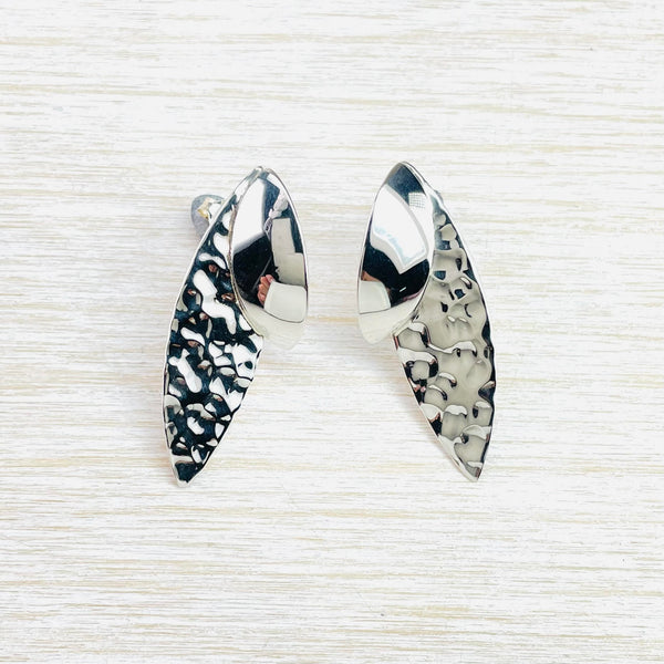 Two elongated leaf shapes form each earring. The longer one at the back has a hammered effect finish, the smaller one at he front ( approx a third of the size of the other) sits on top at the top and is very high polished.
