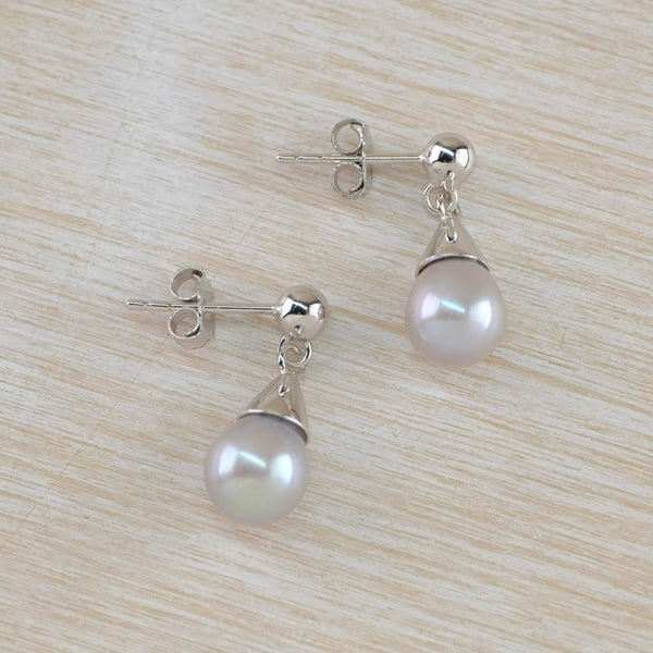 Very shiny glossy pale grey round pearl hangs below a silver traingular shaped silver cap with a silver ball attaching the post and butterfly.