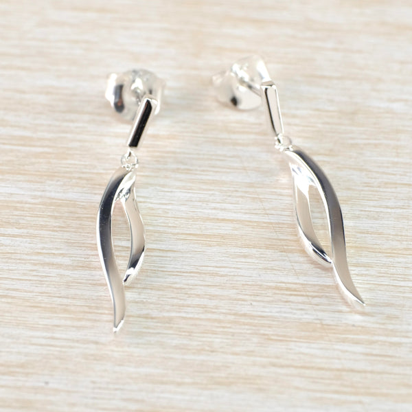 Drop earrings in a high polished look. Two curves join together two thirds down the length of te earring, The top is a delicate silver rod with a post and butterfly fiting attached at the top.