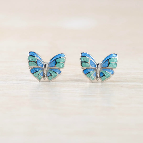 Butterfly design studs with a silver body and silver edges and veins within the wings. Blue and pale green enamel forms the wings.