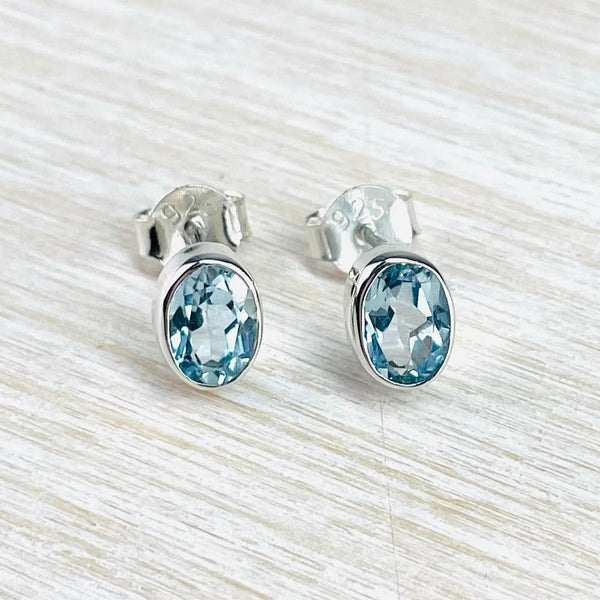 Very simple oval faceted light blue topaz stones are surrounded with a shiny silver frame.