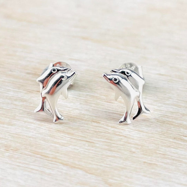 Two leaping dolphins, one behind the other, on each earring. Finished in shiny polished silver, they have smiling faces and open eyes.