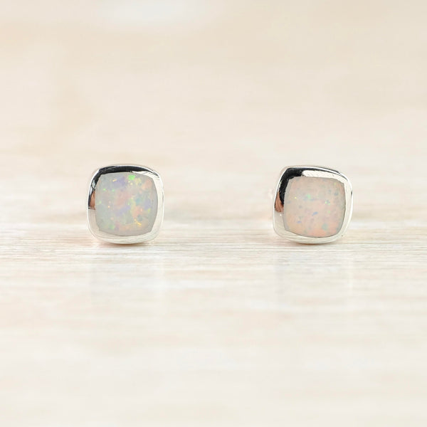 High polished silver squares with sparkly stones set flush to the silver. The stones show colurs of cream, green and pink. They have a silver stem and butterfly fillting attached at the back.
