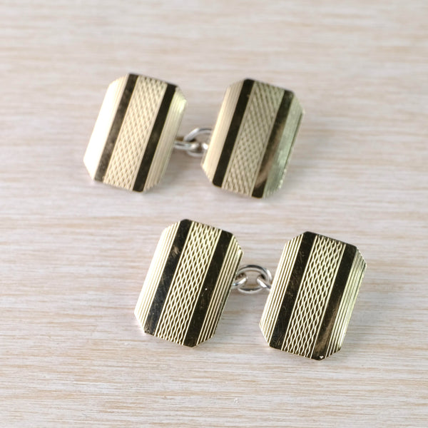 Each cufflink is formed of two identical  8 sided shapes, a sort of rounded rectangle with angles. The pattern is 5 stripes, on the outer sides are narrow vertical stripes, then two plain sections and the middle is a fine trellis design. The two halves are joined by a chain. 
