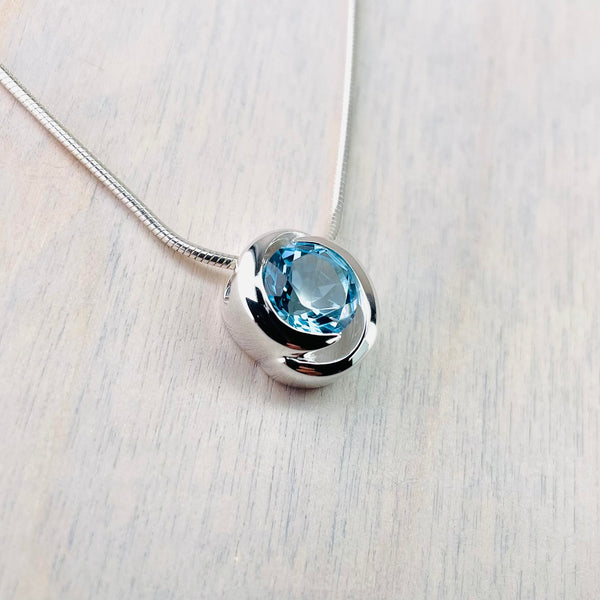 High Polished Silver and Circular Blue Topaz Pendant.