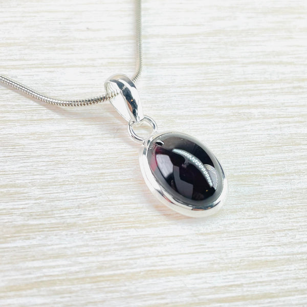 Oval Sterling Silver and Cabochon Garnet Pendant.