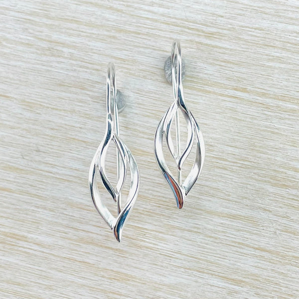 Two open wavy shapes, a smaller inside a larger,  are connected to a solid silver hook - no jump rings , just a solid silver stick in the front and a long feature hook at the back. Each of the wavy shapes has a satin finish inside and a polished edge.