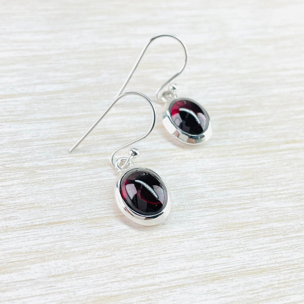Oval Sterling Silver and Cabochon Garnet Drop Earrings.