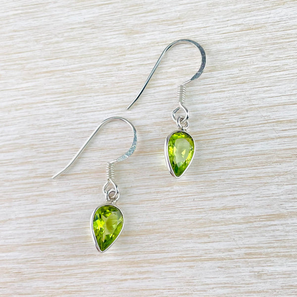 bright light green amethyst stones - cut to sparkle -are set in an upside down tear drop shape silver surround. Hanging from a silver hook.