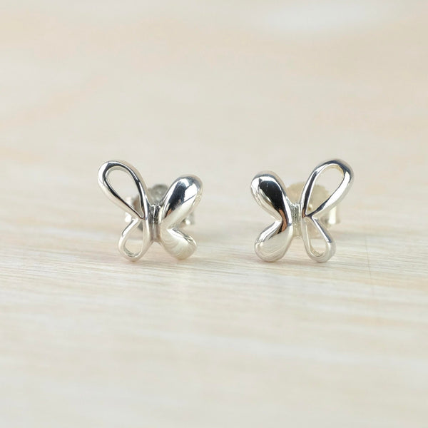 Butterfly shaped earrings. Each one has a larger wing on the outside which is just an outline and a slightly smaller solid wing on the  inside.