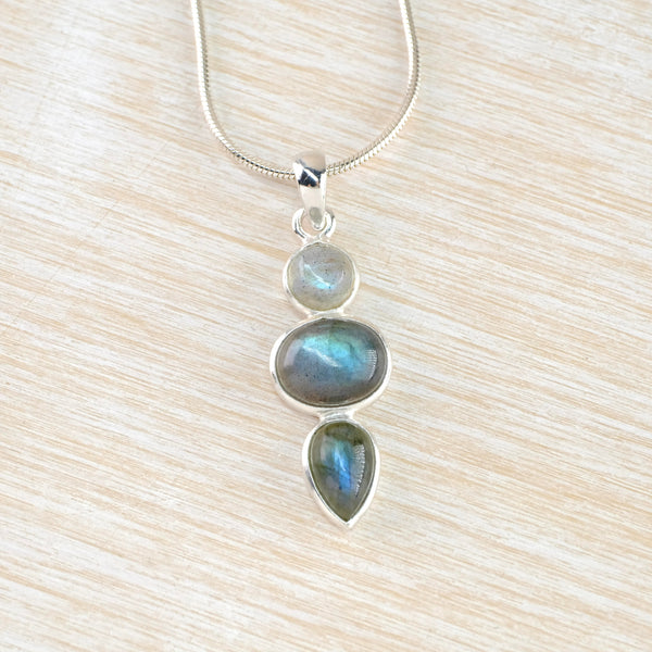 Three stones drop down from each other - a round one then a larger oval, then a smaller pear shape. All are blue/grey /green with random markings and each is seperatley framed in silver.