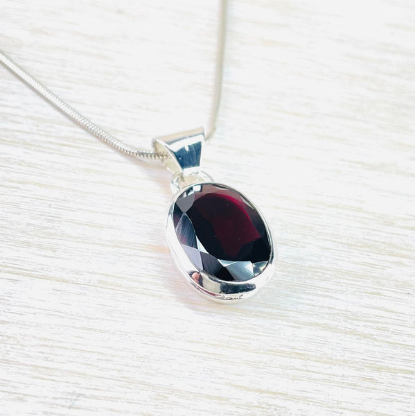 Oval Sterling Silver and Faceted Garnet Pendant.