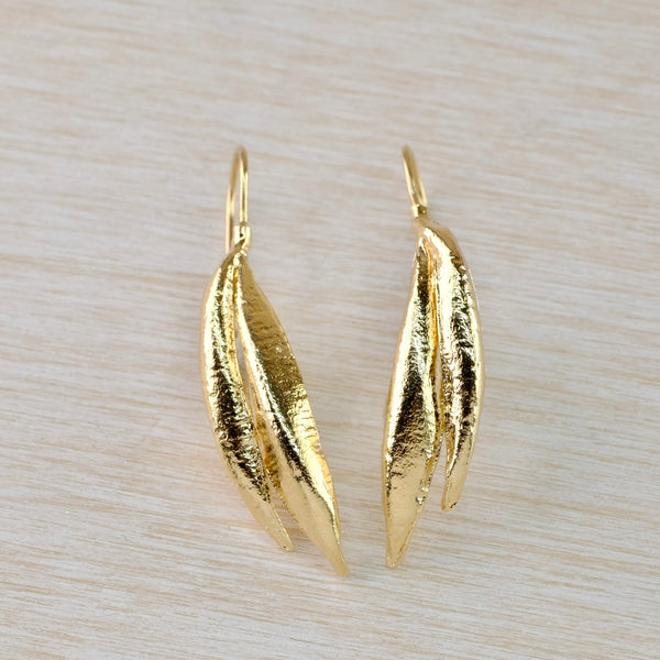 Bright gold double leaf shape earrings. Each earring has two long narrow leaf shapes,  the outer one being slightly shorter.