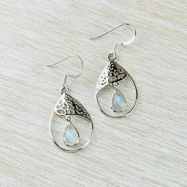 The overall shape is tear drop. In the top third of this is a filligree design with pretty cut outs and a wave shape edge. Hanging from this is a tear drop shape transluscent blue/grey stone set in silver.