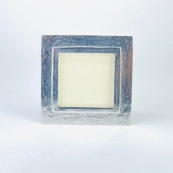A square pewter photograph frame, in a grey colour, with a delicately hamm look finish . The inner opening is framed with a single line in a polished pewter finish about half a centimeter in