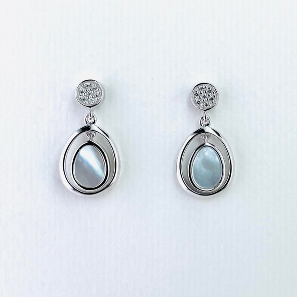 Earrings in two parts.The top piece is a silver circle studded with seven sparkly cubic zirconia stones. The bottom part, much bigger, is a soft tear drop shape, itself in two parts. The outer part is shiny silver with a smaller tear drop mother of pearl hanging inside, connected at the top.
