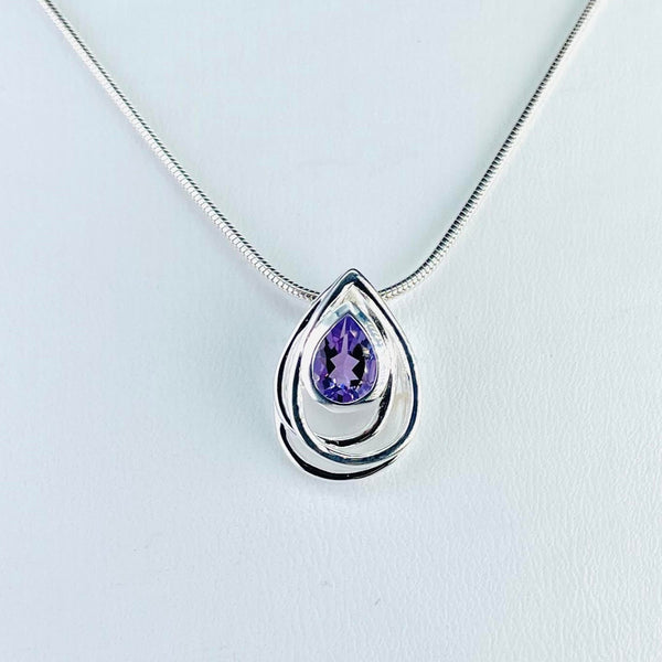 Tear drop shaped pendant with a sparkly teardrop amethyst stone set in the top half, surrounded by three tear drop shaped silver surrounds all slightly off set from each other,