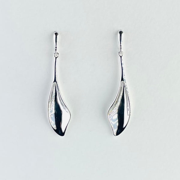 Long polished silver earrings. The bottom half is shaped a little like half a whale's tail with a slight scooped shape. Above this is a narrow silver rod, attached to a polished tear drop shape with the post and butterfly fitting attached.