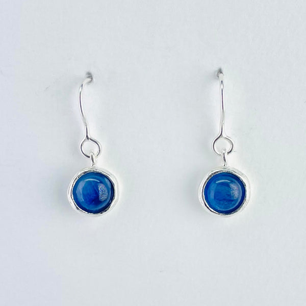Simple round vivid blue stone set in round silver setting attached to a silver hook by a circle of silver. silver