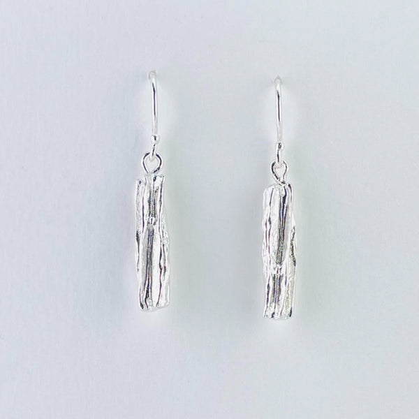 Rectangular drop earrings, textured , they look like the bark of a tree. Attached to a silver hook by a plain silver circle.