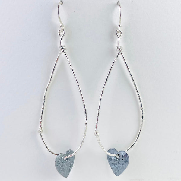 Long silver pear drop shape outline with a dark silver heart threaded through the bottom. Very elegant..